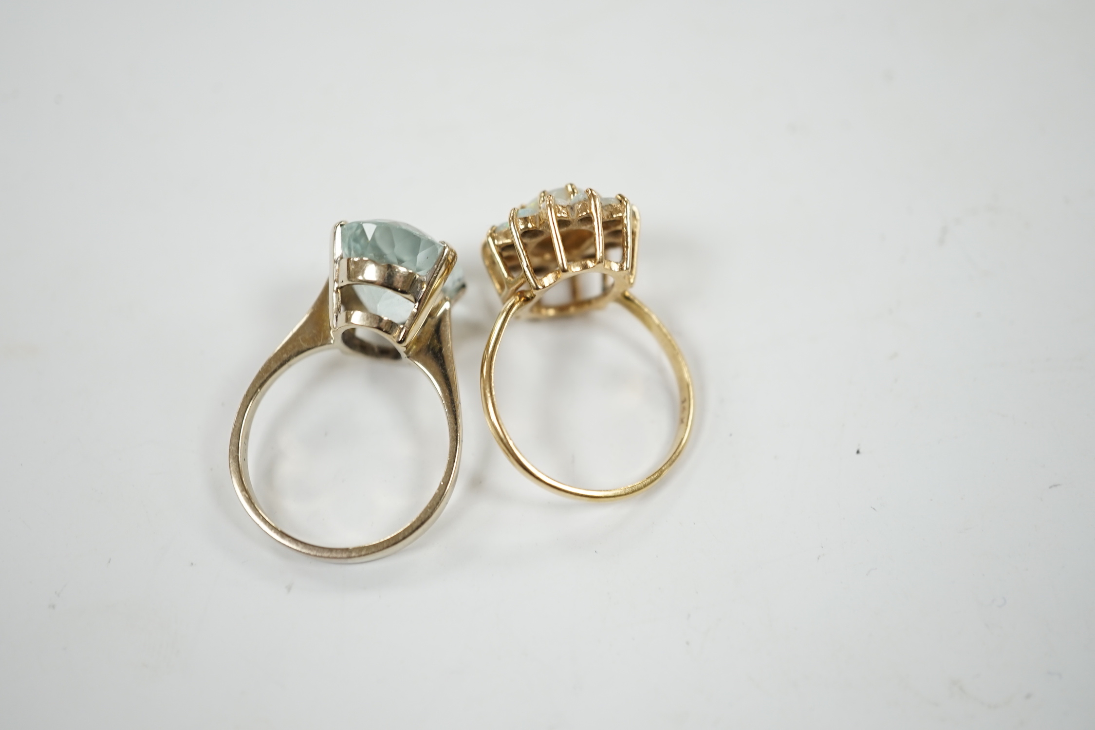 A 14k yellow metal and white opal set oval cluster ring, size P/Q, gross weight 4.1 grams and a gilt white metal? and oval fancy cut aquamarine set ring.